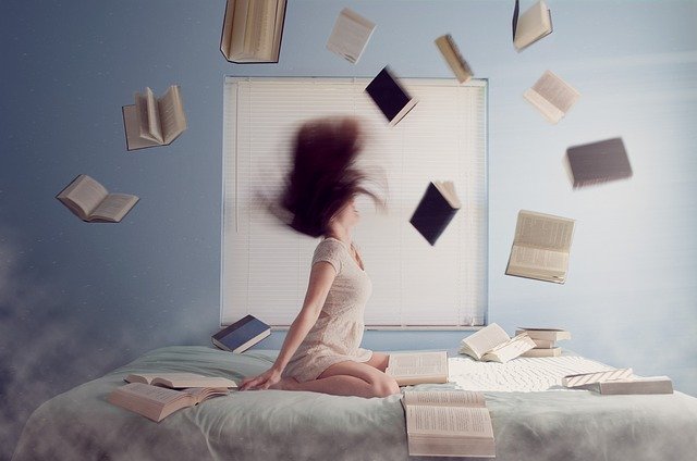 Mujer estudiando y libros flotando